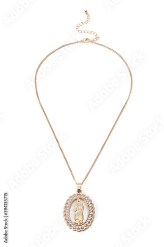 Detailed shot of golden necklace with oval pendant made as Holy Virgin figure in open-work frame with crystals. The stylish chain with pendant and extension chain is isolated on the white background. 