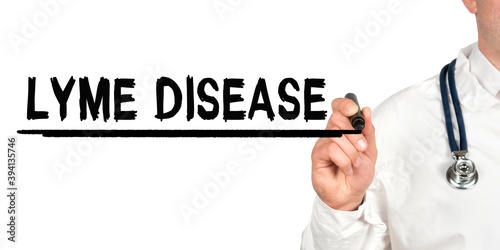 Doctor writes the word - LYME DISEASE. Image of a hand holding a marker isolated on a white background.
