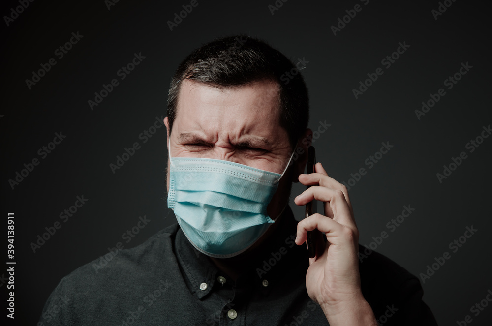 a man in a medical mask talking on the phone a man in a medical mask talking on the phone