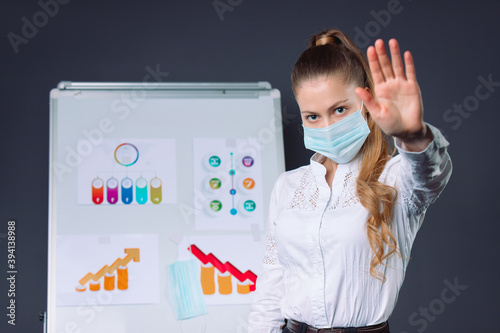 Ladyboss in a medical mask shows stop during a conference. Virus concept. photo