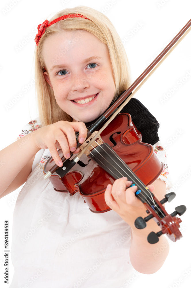 Smiling young blonde girl plays violin on a white studio background Smiling young blonde girl plays violin on a white studio background