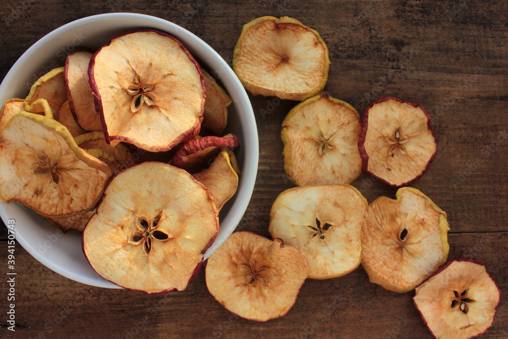 Fototapeta premium Dried fruits apples rings in a bowl, on wooden background. Top view. Rustic style