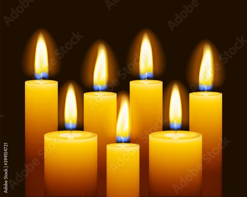 Set of three burning candles on dark background