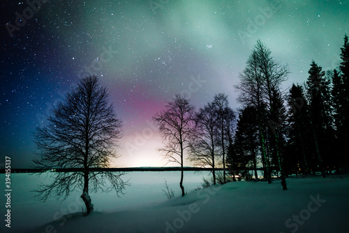 Northern lights Aurora Borealis activity over the lake in winter Finland