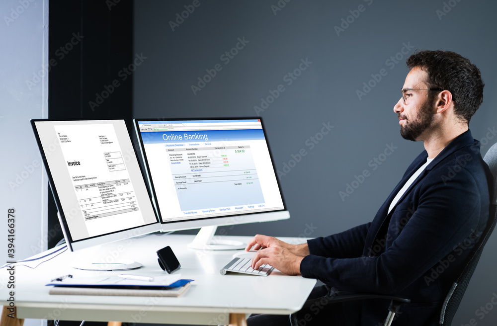 Young Businessman Looking At Invoice While Doing Online Banking