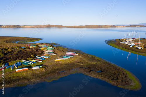 Colorful kayaks and small boats lie on the beautiful shoeline of Morro Bay in Central California. This region is known for its kayaking, sailing, surfing, fishing, and amazing coastlines. photo