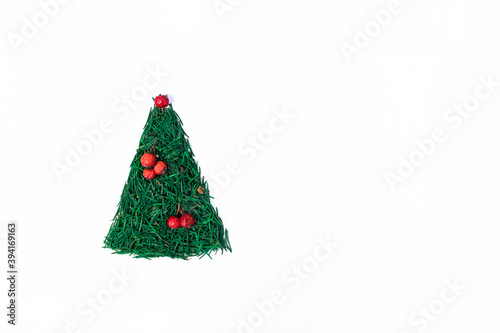 Christmas tree made of spruce needles, decorated with red rowan berries on white background. Christmas, New Year minimalistic concept.