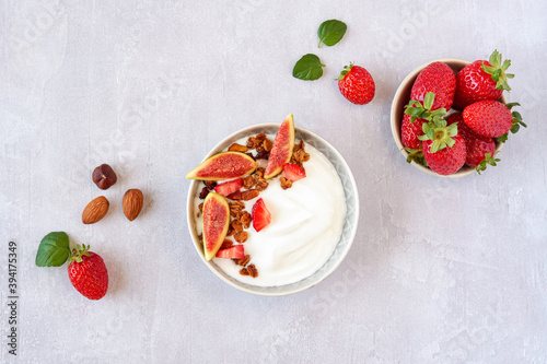 Greek yogurt with granola ,strawberry and fig in the bowl . Top view with copy space