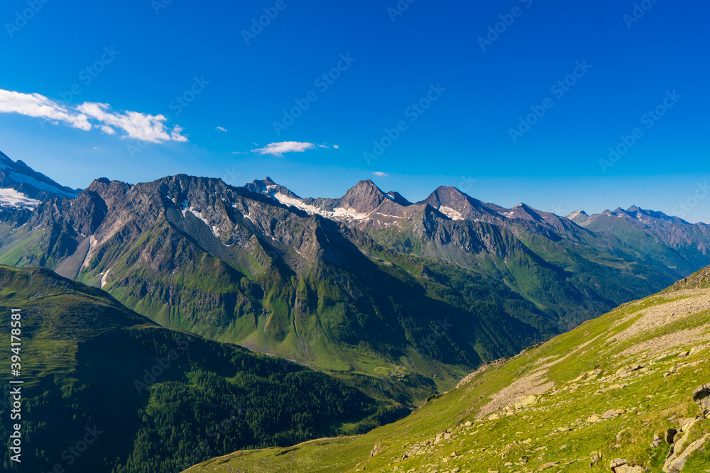 Landscape mountain view peaks in snow and green hills, deep blue sky and huge white clouds background, Hohe Tauern Austrian Alps, Europe Landscape mountain view peaks in snow and green hills, deep blue sky and huge white clouds background, Hohe Tauern Austrian Alps, Europe