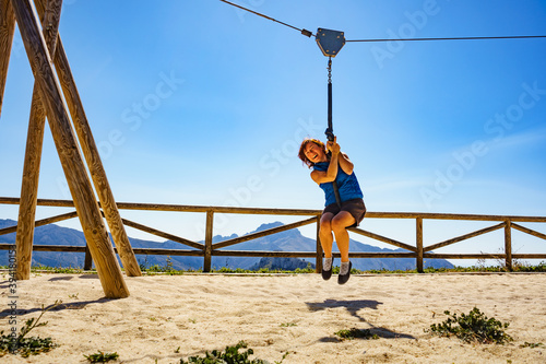 Adult woman having fun on zipline © Voyagerix
