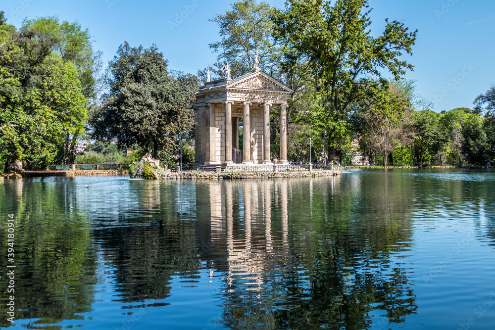 Small lake with trees reflecting in the water in Villa Borghese park