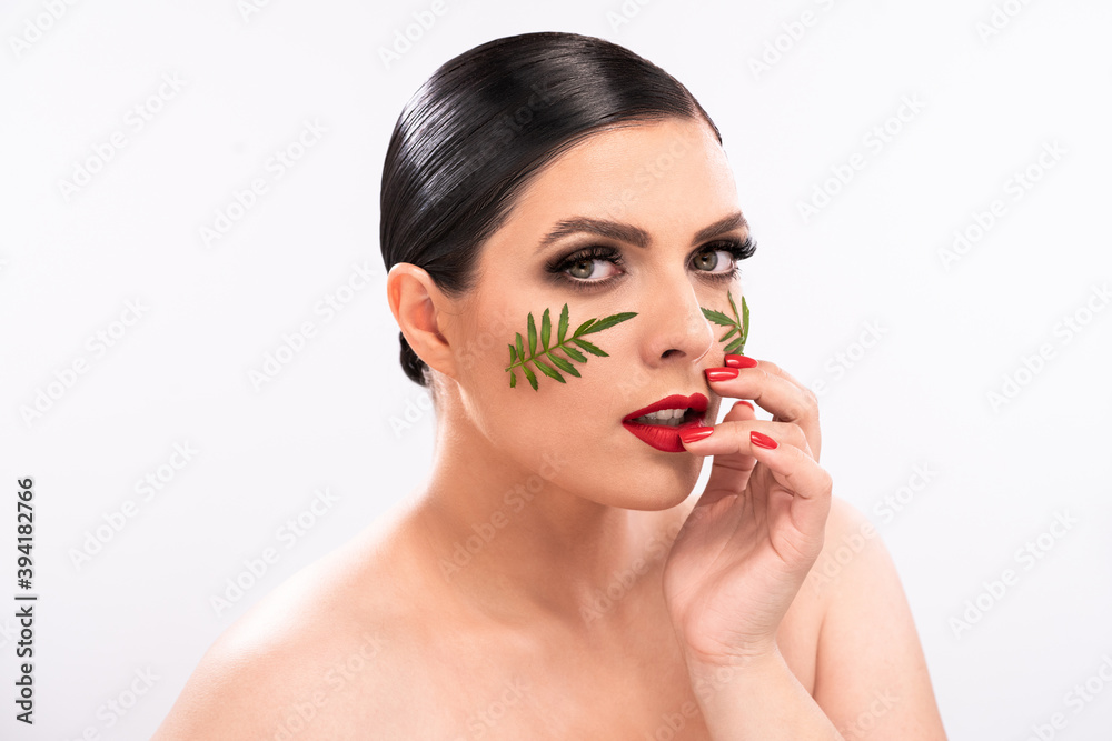 Beauty woman. Beautiful female model with perfect clean fresh skin with green leaves patches on her face. Skin care treatment or cosmetic ads concept. Isolated on white background. Beauty woman. Beautiful female model with perfect clean fresh skin with green leaves patches on her face. Skin care treatment or cosmetic ads concept. Isolated on white background.