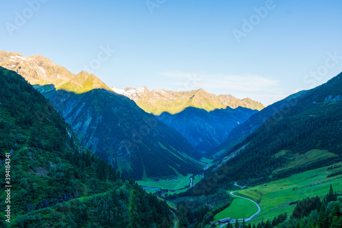 Panoramic view with sunrise on idyllic mountain backdrop in the Alps with fresh green meadows in summer Stange near Zillergrundl. Austria Zillertaler Alpen tirol