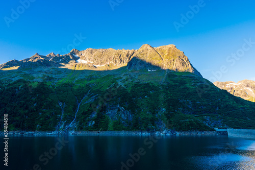 Panoramic view with sunrise on idyllic mountain backdrop in the Alps with fresh green meadows in summer Stange near Zillergrundl. Austria Zillertaler Alpen tirol photo