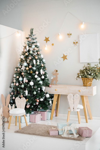 Cozy bright children s room with a Christmas tree  chair and toys in a light color