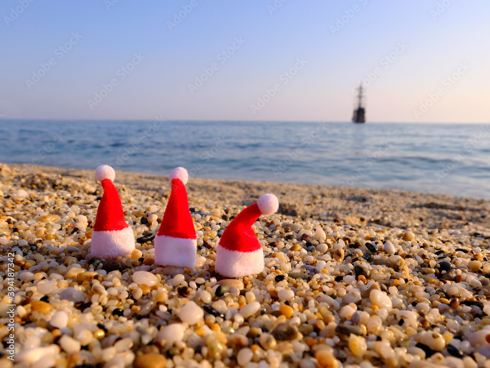 Santa claus hat on the seaside. Rest during a pandemic. Quarantine during the holidays. Travel agency crisis Santa claus hat on the seaside. Rest during a pandemic. Quarantine during the holidays. Travel agency crisis