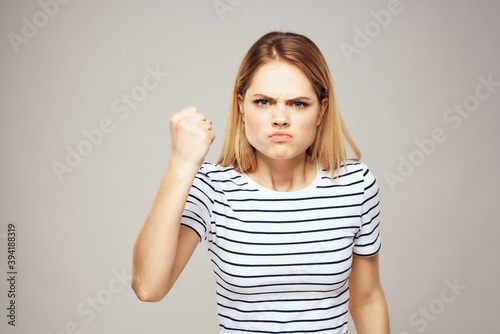 Emotional blonde woman in striped t-shirt lifestyle facial expression close-up 