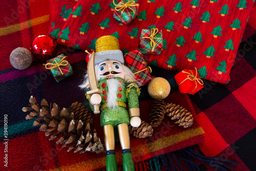 Flat lay nutcracker soldier decoration lying among other holiday items and colourful fabrics © Anne Richard