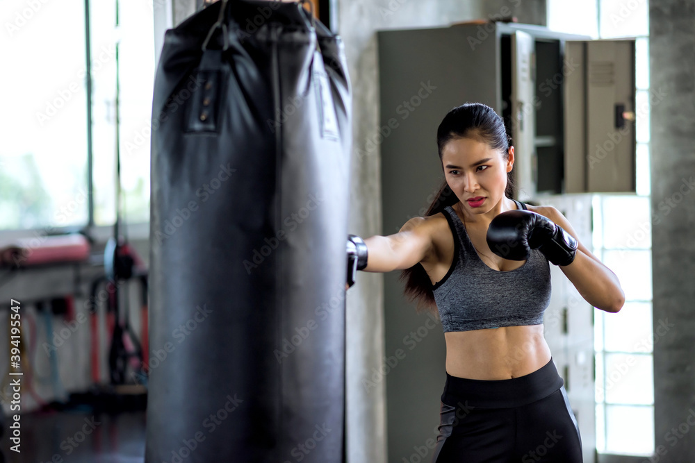 Attractive female boxer training boxing at gym