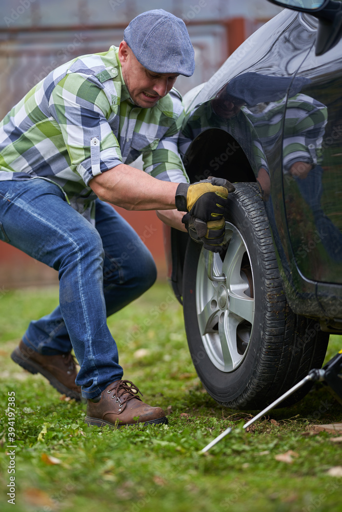 Obraz premium Man changing a flat tyre
