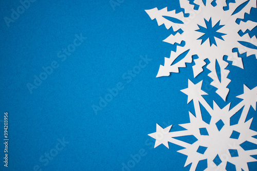 Handmade paper snowflakes on blue background