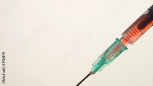 Filling vaccine or medication syringe with blood from vein, extreme macro. Administrating meds mixing with patient blood and sterile medical needle, coronavirus antivirus injection for immunization.