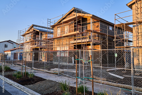 Exterior of New home construction with scaffolding scaffolds; single family homes under construction in California 