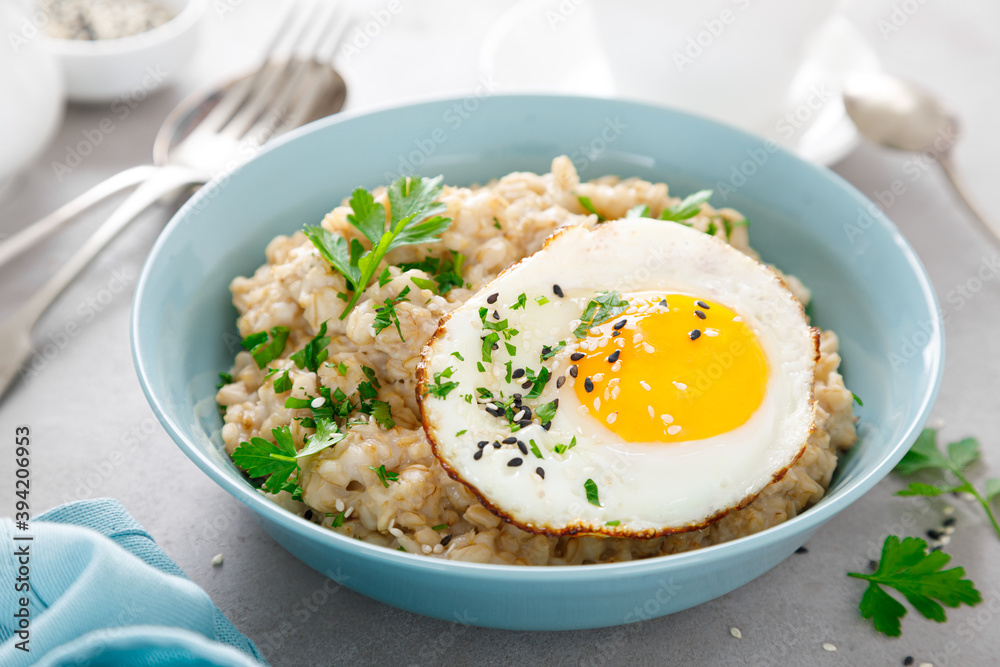 Savoury oatmeal with fried eggs sunny side up for breakfast Savoury oatmeal with fried eggs sunny side up for breakfast