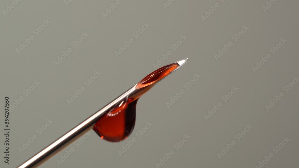 Drops of blood from the tip of the medical syringe. Bloody liquid dripping from needle, macro close up. Addiction horror illustration. Used syringe needle in blood. Administration of street drugs. Drops of blood from the tip of the medical syringe. Bloody liquid dripping from needle, macro close up. Addiction horror illustration. Used syringe needle in blood. Administration of street drugs.