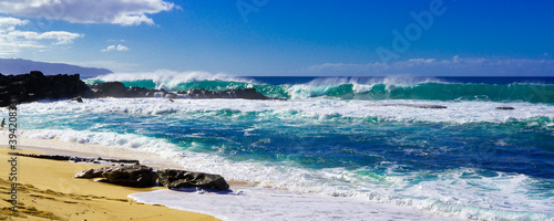 Huge crashing waves on the rocks and sandy beach at Three Tables. Beach Oahu Hawaii