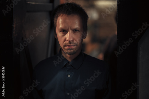 young man looking threateningly at the camera at night indoors