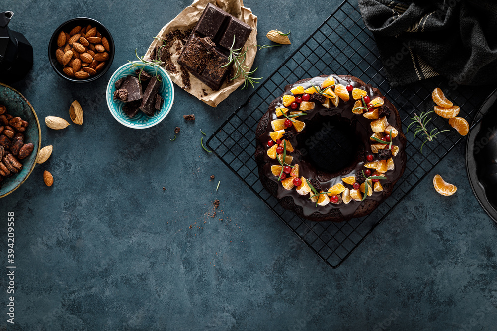 Christmas chocolate bundt cake with ganache decorated with oranges, berries and rosemary Christmas chocolate bundt cake with ganache decorated with oranges, berries and rosemary