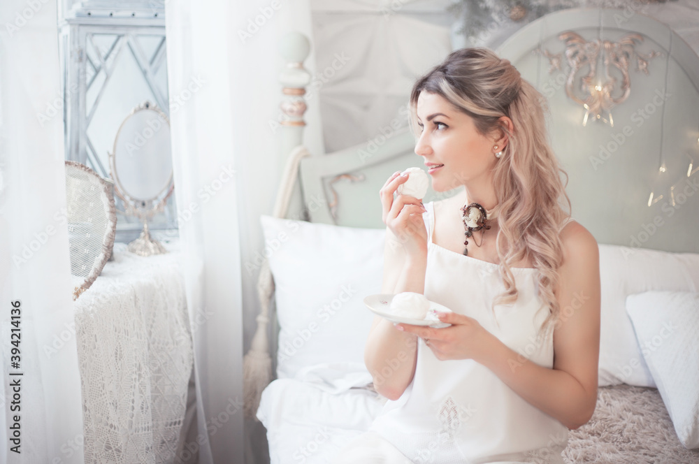 Cute young woman eating sweets in the morning in the bedroom. Gentle winter morning. Cute young woman eating sweets in the morning in the bedroom. Gentle winter morning.