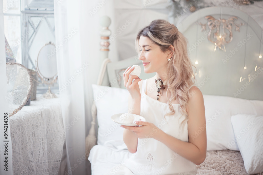 Cute young woman eating sweets in the morning in the bedroom. Gentle winter morning. Cute young woman eating sweets in the morning in the bedroom. Gentle winter morning.