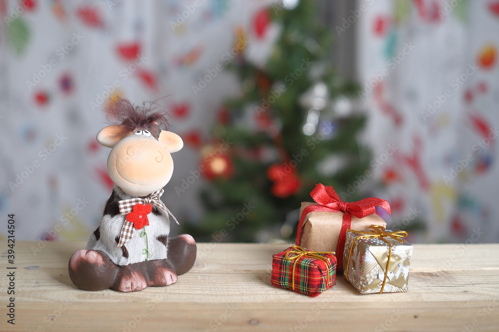 toy bull and gifts on the background of a Christmas tree