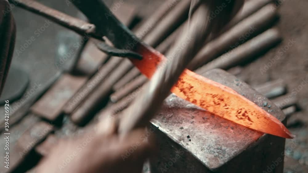 Extremely red hot steel knife hammered to take up shape Extremely red hot steel knife hammered to take up shape