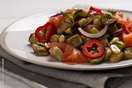 Traditional Sicilian dish of eggplant caponata, in a plate, on a wooden table