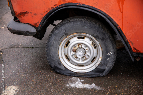 Deflated damaged tire on the wheel of an old car © fotoru