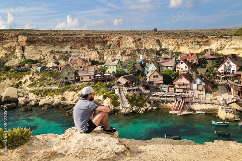 Homme regardant le village de Popeye à Malte photo