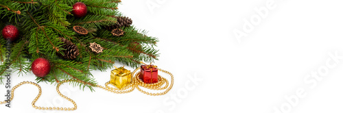 Branches of a Christmas tree and red and yellow gift boxes and balls on a white background. Christmas background with copyspace.