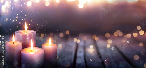 Abstract Advent - Four Purple Candles With Soft Blurry Lights And Glittering On Flames