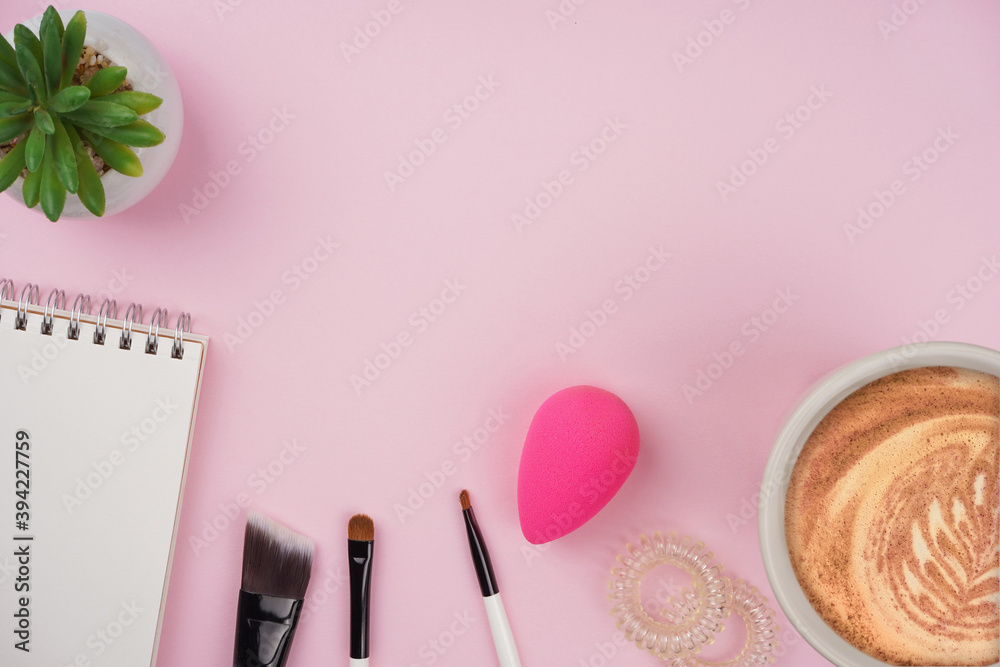 Makeup tools set, notebook, coffee cup, plant on pink background. Beauty blogger workspace, cosmetic concept. Top view, flat lay, copy space Makeup tools set, notebook, coffee cup, plant on pink background. Beauty blogger workspace, cosmetic concept. Top view, flat lay, copy space