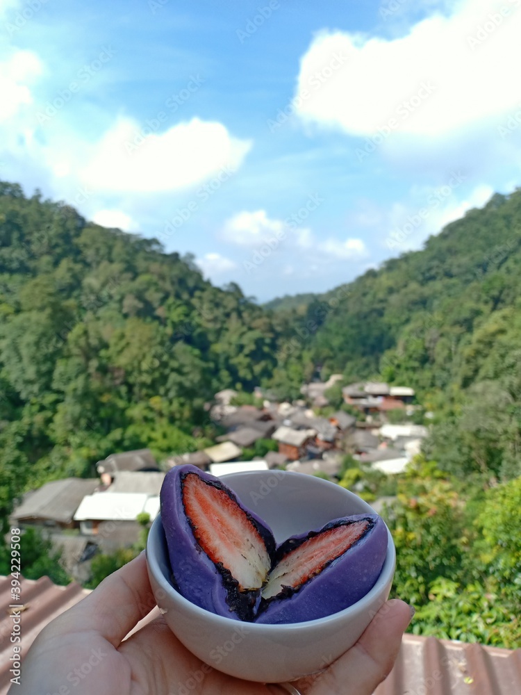 25 October 2020, The front is a strawberry mochi. The view is a village of Mae Kampong. Chiang mai, Thailand.