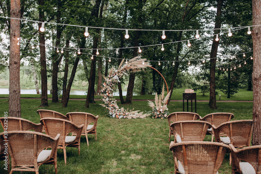 Flower arch. Wedding floral decorations from roses. Decoration for the ceremony. Place for guests. Summer playground.