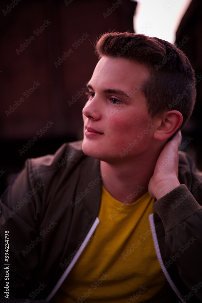 Fototapeta premium A young man sitting on the railways and looking forward.