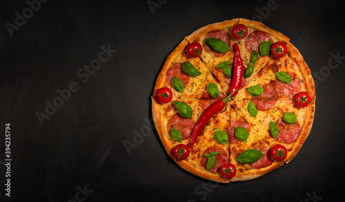 Creative design. Pizza time. Pizza clock and peppers clock hands. Place for copy and paste. Black blackboard as background. Flat lay.