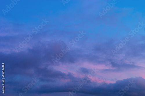 Background of mystery purple and pink clouds on blue sky at evening after sunset. Telephoto zoom photo shot © Aliaksei