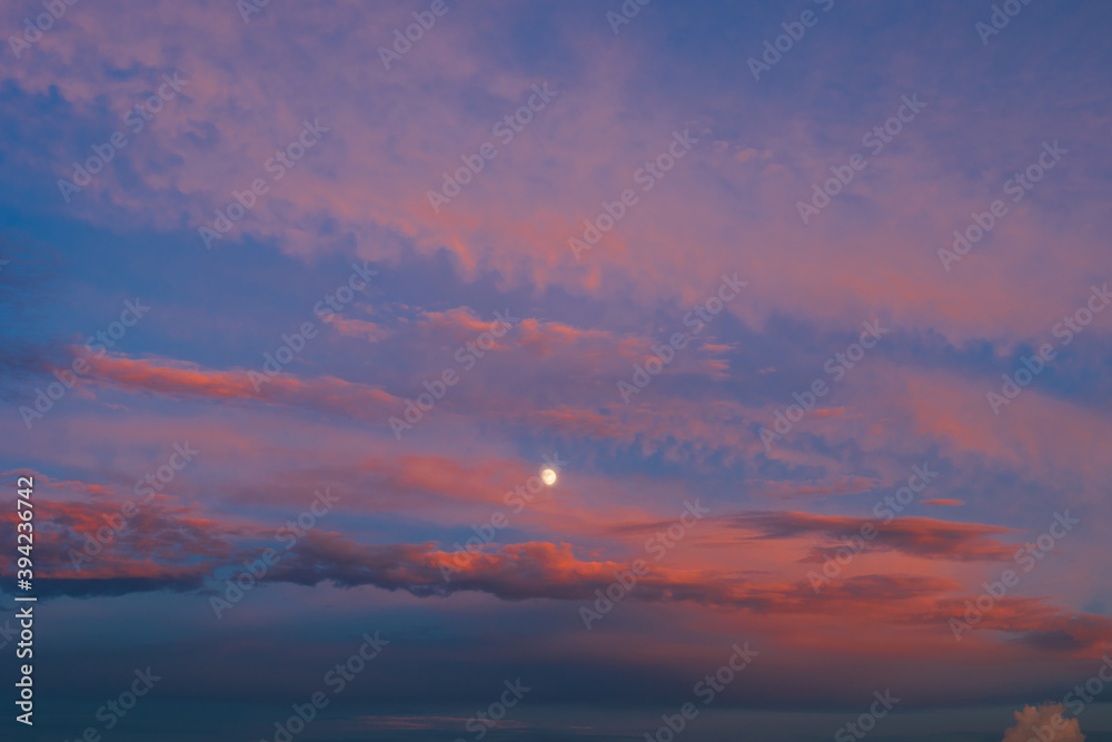 Background of amazing mystery red and yellow clouds illuminated by rays of evening sun on blue sky at sunset. Telephoto lens photo shot Background of amazing mystery red and yellow clouds illuminated by rays of evening sun on blue sky at sunset. Telephoto lens photo shot