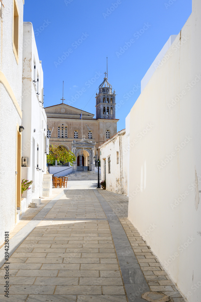 Narrow street in Lefkes village on Paros Island. Church of Agia Triada in background. Greece