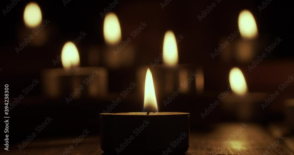 Group of burning tea candles and blowing them out